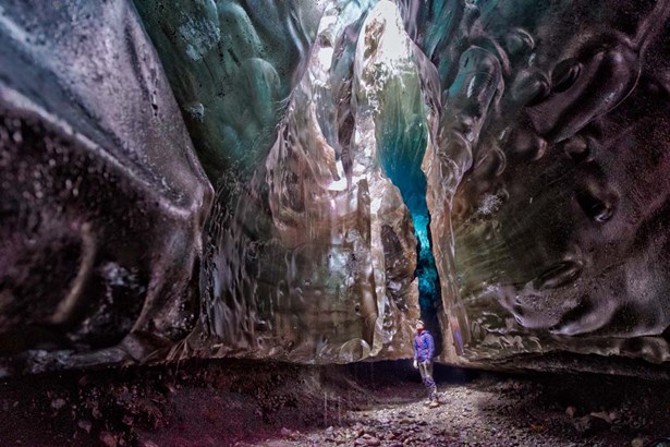 man exploring huge ice cave in Iceland
