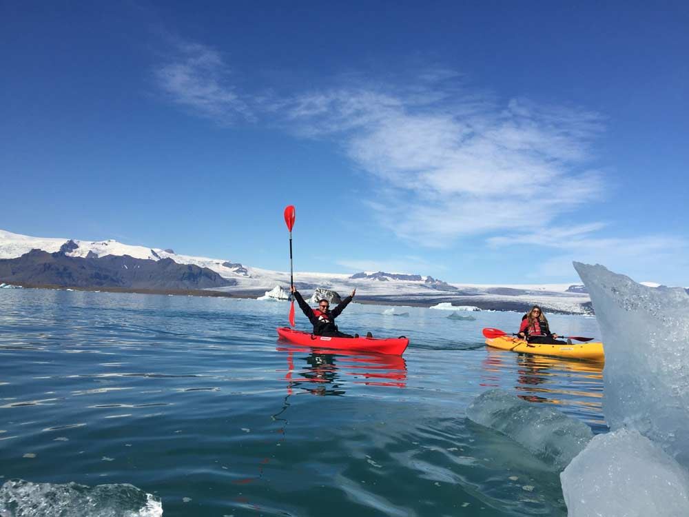 happy couple kayaking in glacier lagoon