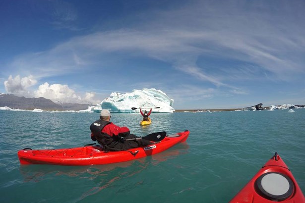 excited kayakers paddling in Jokulsarlon glacial lagoon