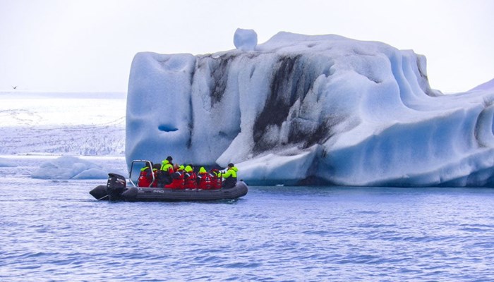 zodiac boat near huge iceberg in Jokulsarlon lagoon