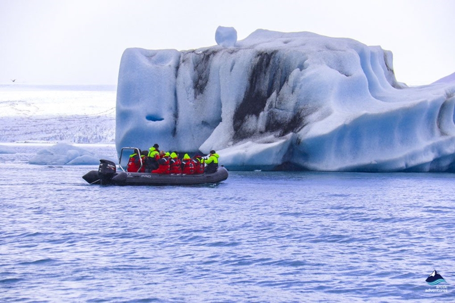 zodiac boat near huge iceberg