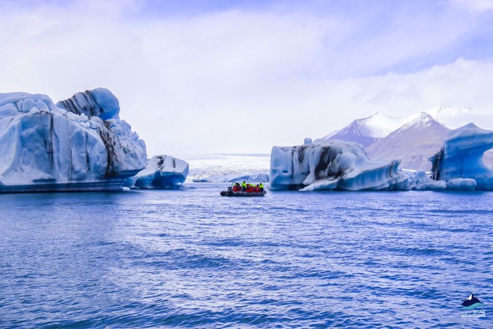 boat swimming between icebergs