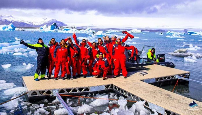 tourists group on footbridge in glacier lagoon