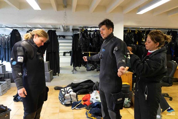 people dressing up dry suits for dive training