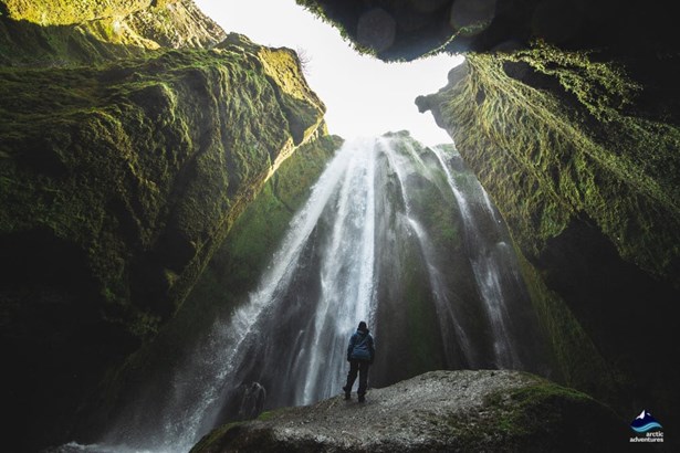 Man inside a cave near Gljufrabui Waterfall in Iceland
